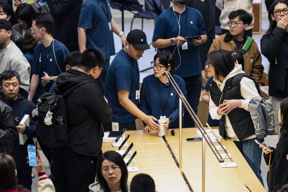 Customers at an Apple retail store opening iOS 26 با طراحی Liquid Glass، زمینهساز تغییرات در آیفون ۲۰۲۷ خواهد بود! - دیجینوی