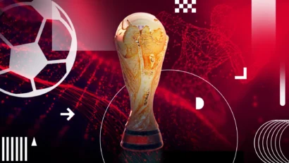 Golden FIFA World Cup trophy centered against a red abstract background with geometric shapes and circular lines, symbolizing soccer glory.
