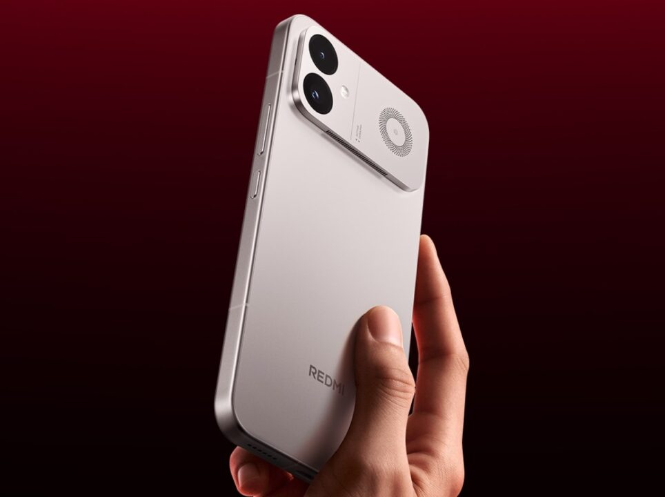 Back view of a silver Redmi smartphone being held in a hand, showing the dual-camera module and circular speaker on the top corner against a dark red background.