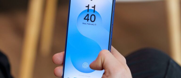 Close-up of a hand holding a blue smartphone showing the fingerprint unlock icon on the screen.