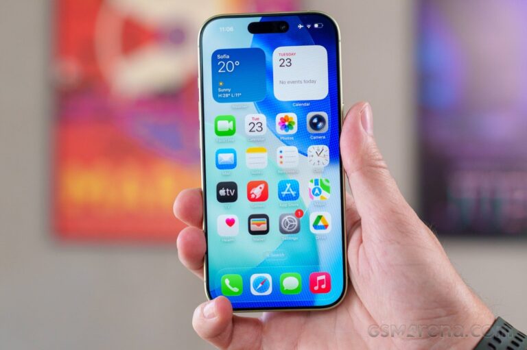 Hand holding a smartphone (iPhone) displaying home screen with app icons and widgets in focus.