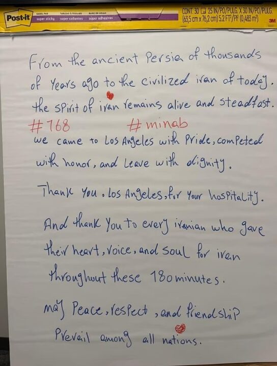 Handwritten note on white paper with a yellow Post-it border at the top. The message thanks Los Angeles for hospitality and Iran for pride, honor, dignity, and peace, mentioning hashtags “#168” and “#minab,” and thanking Iranians for their heart, voice, and soul for Iran over 180 minutes, ending with a wish for peace and friendship among all nations.