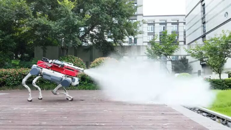 Four‑legged robot with a red spraying apparatus releasing a jet of mist on a wooden deck in a green courtyard.